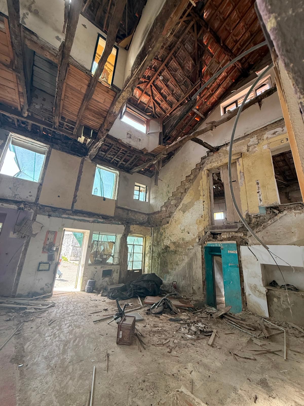 Interior de pé-direito duplo com estrutura de madeira original — AXIS I em obras